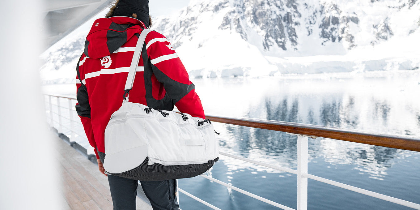 man wearing a white duffel bag while on an arctic cruise in Antarctica