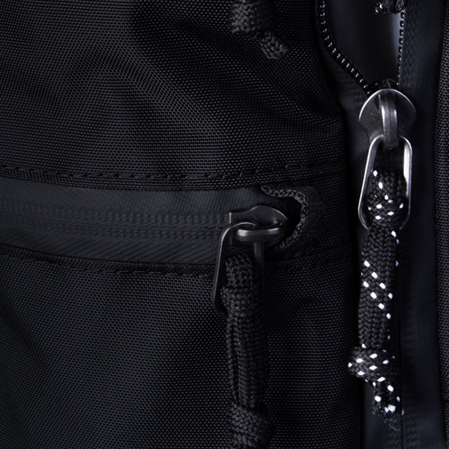macro shot of 2 zipper pullers on black bag