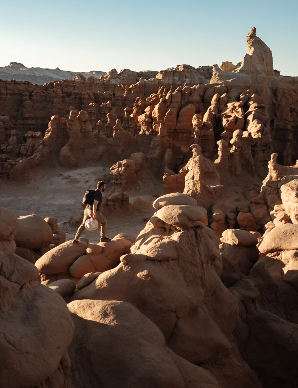 Man walking along otherworldly desert rock formations