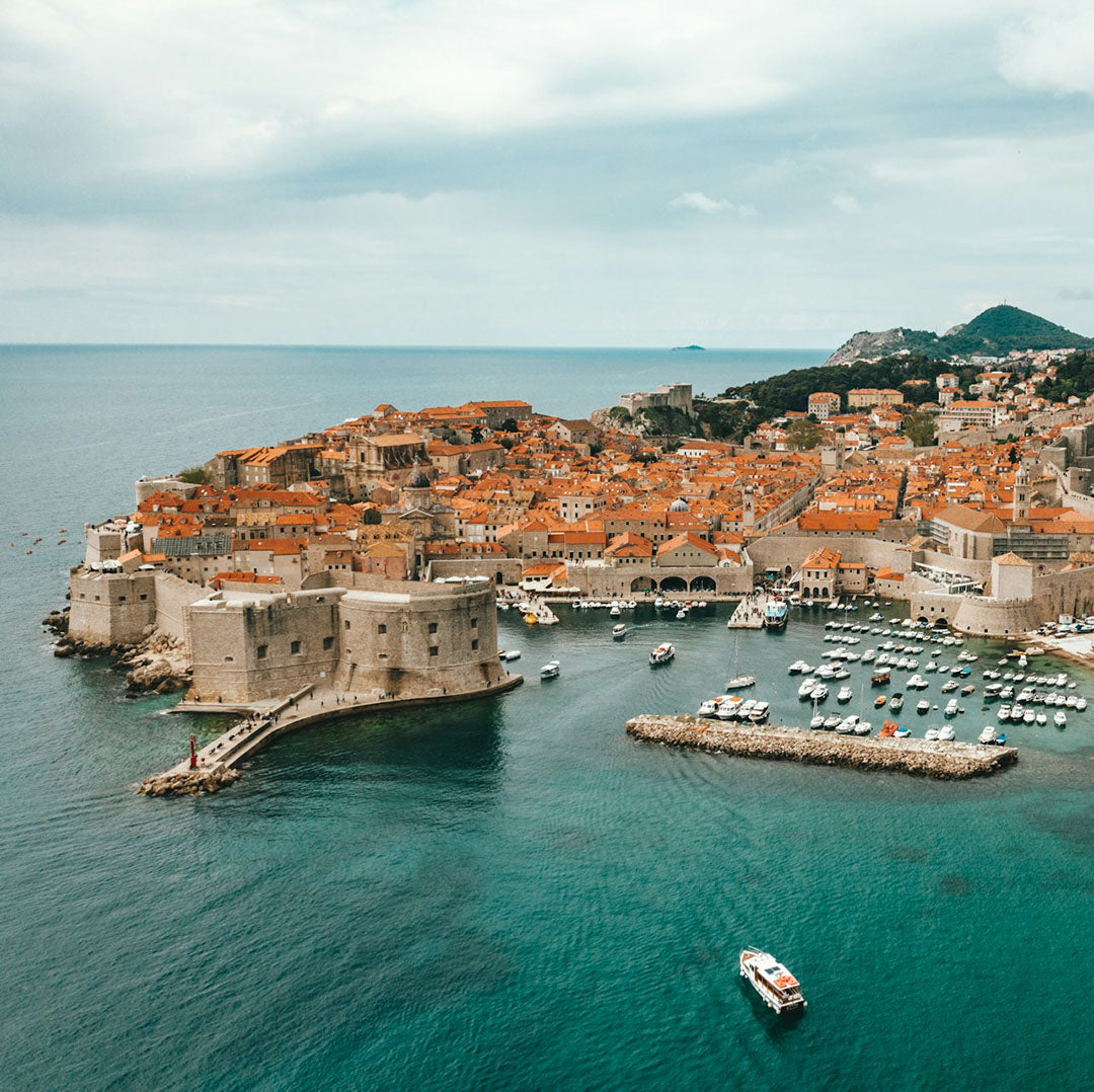 Aerial view of a coastal city with orange buildings and a harbor.