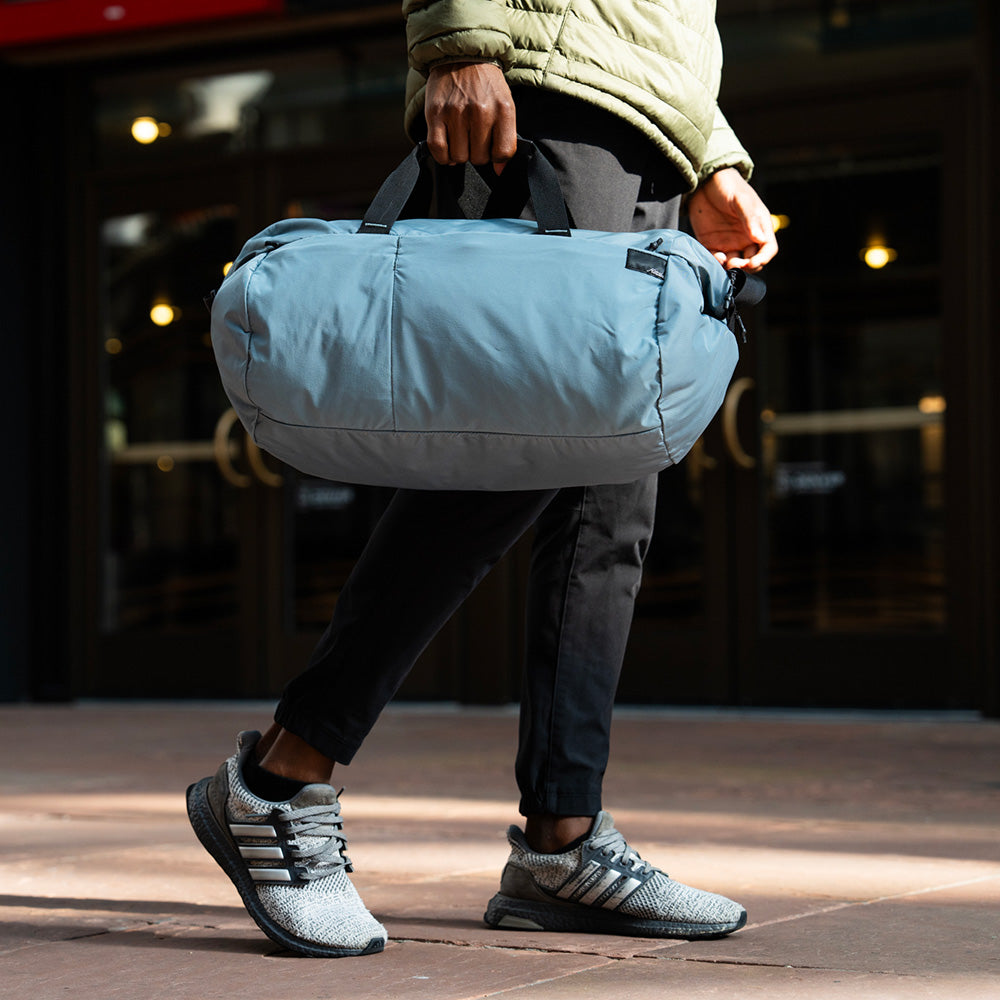 person holding a duffle bag