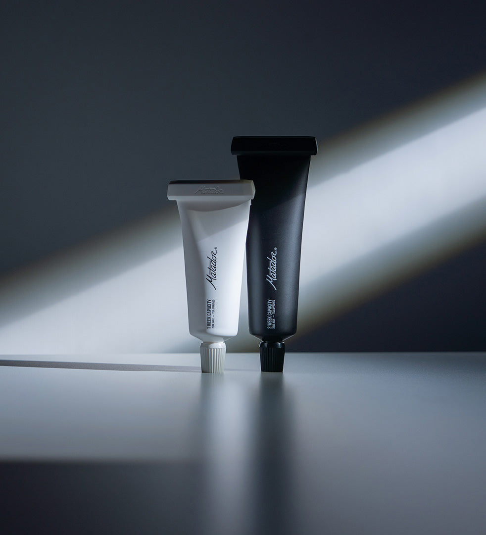 black and white refillable toothpaste tubes standing up on a counter