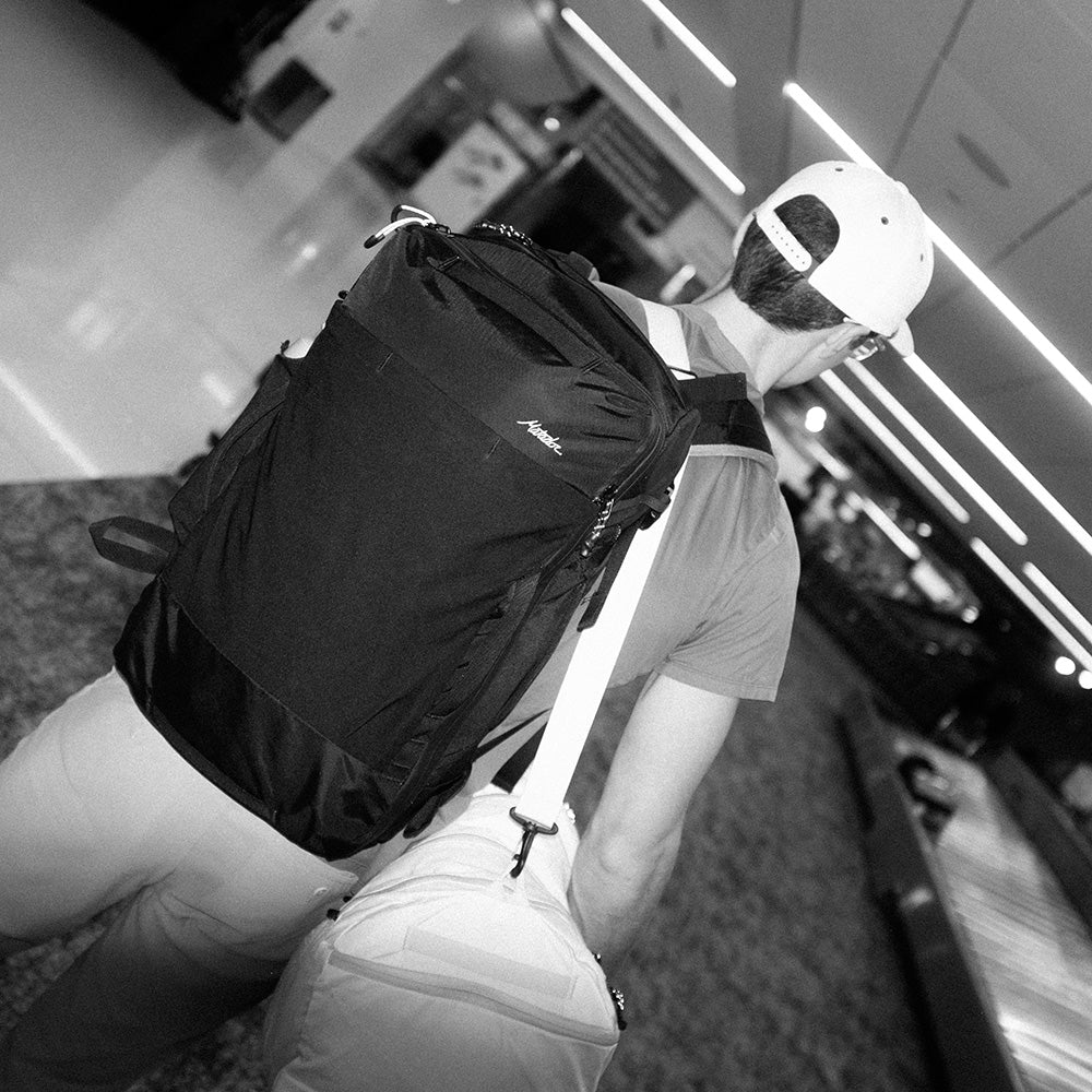 man wearing durable travel backpack and duffle at the airport